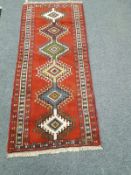 A Caucasian design rug on red ground,