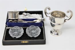 A miniature silver trophy, silver sugar tongs and other flatware,
