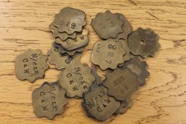 Twenty vintage brass railway pay check tokens.