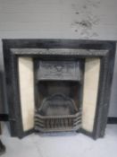 A Victorian cast iron fire with tiled panels