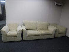 A three-piece lounge suite upholstered in sand coloured fabric