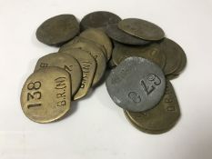 Nineteen vintage brass railway pay check tokens.