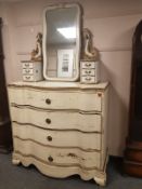 A 19th century continental cream and gilt serpentine front dressing chest with mirror back,