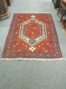 A Caucasian design rug on red ground,