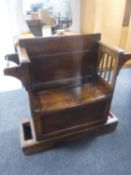 An Edwardian oak storage hall seat with stick stands