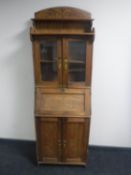 An antique carved pine continental bureau bookcase