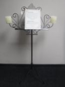 A wrought metal music stand with candle holders
