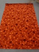 A hand-knotted rug on orange ground,