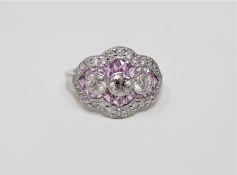 An 18ct white gold sapphire and diamond ring featuring 3 centre round brilliant cut diamonds,