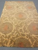A hand-knotted rug of floral design on gold ground,