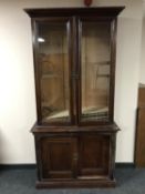 A pitch pine glazed door bookcase fitted sliding door cupboards beneath