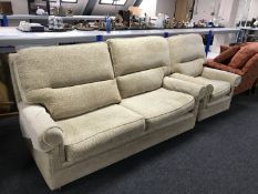 A three seater settee and armchair upholstered in beige print retailed by Delcor