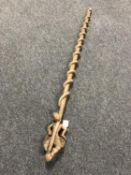 An antique carved wooden staff with serpent carved decoration
