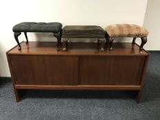 A teak effect sliding door sideboard together with three footstools