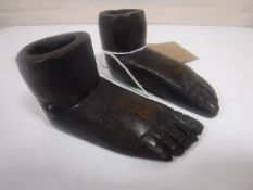 A pair of antique folk art treen candlesticks modelled as a pair of feet, length 9 cm.