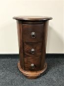 An Indonesian mahogany cylindrical three drawer chest