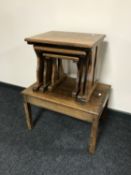 An oak coffee table together with a nest of three oak tables