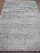 A hand knotted shaggy light blue rug,
