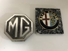 An MG car badge together with an Alfa Romeo car badge
