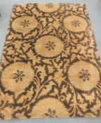 A hand-knotted rug of floral design on brown ground,