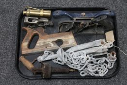 A tray containing vintage woodworking planes, antique brass burner containing wicks,