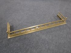 A Victorian brass fire curb