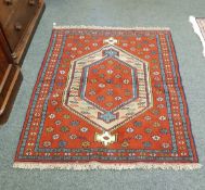 A Caucasian design rug on red ground,