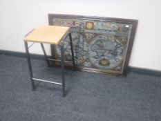 A framed picture mirror of a map of the world together with a metal-legged stool