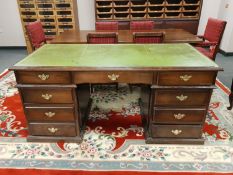 An oak twin pedestal desk with green tooled leather top,