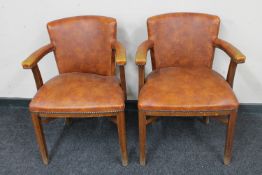 A pair of twentieth century oak armchairs upholstered in brown vinyl
