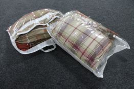 Two bags containing two pairs of tartan curtains, 90