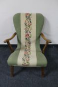 A mid 20th century teak framed armchair upholstered in a tapestry fabric