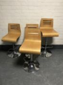 A set of four beech gas lift bar stools