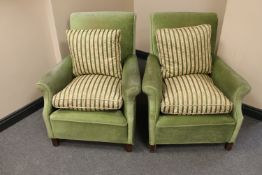 A pair of early 20th century armchairs upholstered in a green fabric with striped cushions