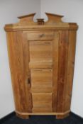 An antique pine corner cupboard