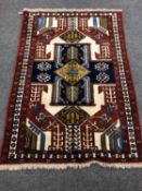 A Caucasian fringed rug on red ground,