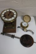An antique brass and enamelled clock movement with pendulum together with a cased travel clock and