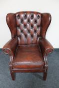 A late 20th century buttoned leather wingback armchair