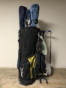 A golf bag containing part set of irons, three drivers, folding golf trolley,