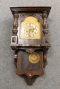 An antique oak cased wall clock with brass dial,