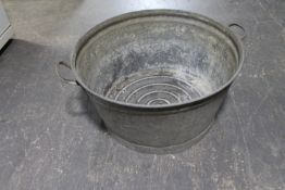 An circular galvanised twin handled wash tub