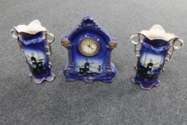 A 19th century three piece pottery clock garniture depicting windmills