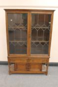 An oak double door bookcase on stand fitted with two drawers