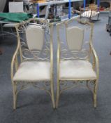 A pair of wrought iron shield back garden armchairs