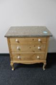 An early 20th century pine three drawer marble topped chest