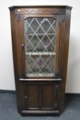 An oak leaded glass corner cabinet