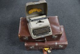 Two vintage leather suitcases and a Triumph typewriter