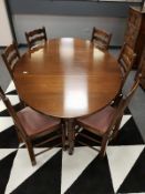 A Reprodux oak gate leg table and six ladder back dining chairs.