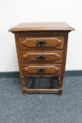 An oak three drawer bedside chest