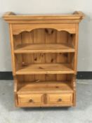A pine wall shelf fitted two drawers beneath